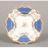 A Rockingham plate with bead moulded lobed rim. Having Brunswick blue and gilt border and painted to