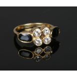 An 18 carat gold ring set with a cluster of four brilliant cut diamonds flanked by a pair of ovoid