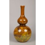 A large Victorian Art pottery vase of double gourd form. Decorated in green, yellow and brown glazes