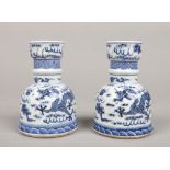 A pair of Chinese blue and white candle stands. Each painted in underglaze blue with a pair of