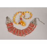 An eastern white metal and coral bead multi row necklet and a butterscotch amber bead necklace