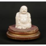 A 19th century Chinese carved ivory figure of a seated Buddha raised on an associated French