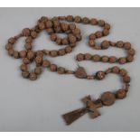 A large carved wooden souvenir rosary with cross and Corpus Christi for Lourdes.