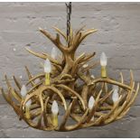 A large rustic themed 12 light composite stag antler chandelier, 55cm x 70cm.Condition report