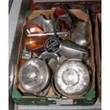 A box of classic MG car parts including chrome examples, badge, head and tail lights.
