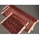 Four carpet runners, red ground with geometric designs, two 190cm x 65cm and two 100cm x 63cm.
