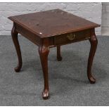 A hardwood single drawer lamp table crossbanded and raised on cabriole legs.