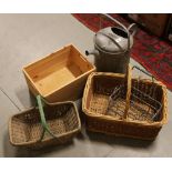 A galvanised steel 3 gallon watering can, along with two wicker baskets and a pine crate.