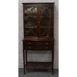 An Edwardian mahogany bookcase with astrigal glazed top, raised on a two drawer base and with