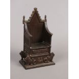 A bronzed money bank formed as a throne, dated 1953.