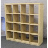 A bank of sixteen beech effect box shelves.