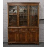 An astrigal glazed mahogany bookcase over drawer and cupboard base.