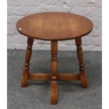 A circular carved and turned oak occasional table.