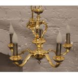 A brass five branch chandelier.