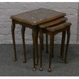 A nest of three bur walnut tables with carved cabriole supports.