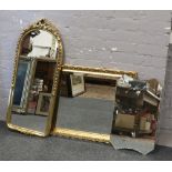 A gilt framed bevel edge wall mirror along with a dome top mirror and a etched glass mirror.