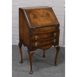 A figured mahogany bureau raised on cabriole supports.