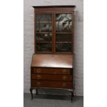 A Victorian astrigal glazed bureau bookcase with fitted interior raised on cabriole legs.