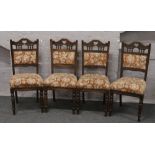 A set of four mahogany dining chairs with carved cresting rails, upholstered back rest and seats,