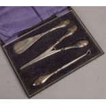 A cased silver handled glove stretcher button hook and shoe horn set, assayed Birmingham 1922.