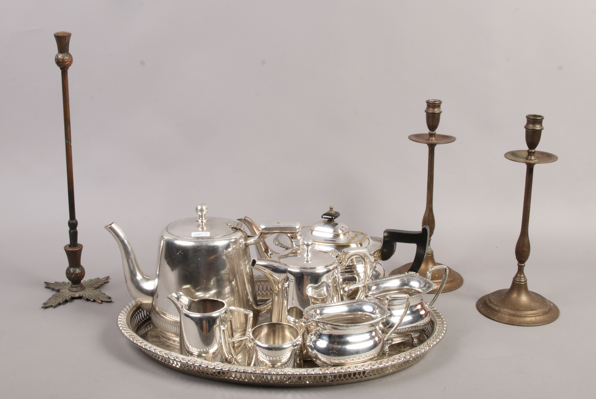 A collection of metalwares to include Viners and Walker & Hall silver plate, brass candle sticks