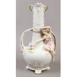 A continental twin handle vase with figural and gilt decoration.