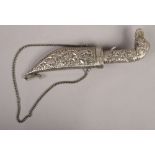 A decorative eastern white metal dagger with repousse decoration and elephant pommel.