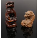 A carved fruit wood netsuke formed as a dragon, signed along with a carving of a dog of fo.