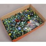 A box of polychrome glass marbles of various sizes.