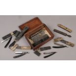 An antique wooden box containing nine boxed cut throat razors, two honing strops and a wetstone