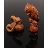 A carved fruit wood netsuke of a perched parrot with glass set eyes, signed, along with a similar