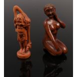 Two carved fruit wood netsuke one formed as a naked female figure and a similar example.