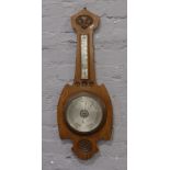 A large carved oak banjo barometer with silvered dial.