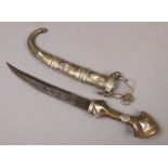 A Middle Eastern Persian style dagger in brass and white metal scabbard.