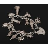 A silver charm bracelet with silver charms to include heart locket, animal examples etc.