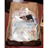 A box of loose used world stamps and first day covers.