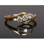 An 18 carat gold three stone diamond ring on diagonal setting. Centre stone approximately 0.2ct.