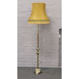 A reeded brass and onyx standard lamp with mustard shade.
