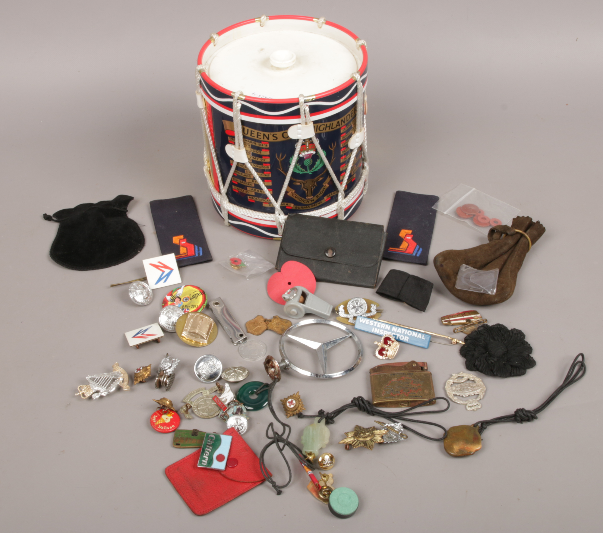 A Queens Own Highlanders drum ice bucket with contents of collectables to include car badges,