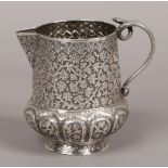 An Indian silver milk jug chased with trailing flowers and having a coiled snake handle, 202 grams.