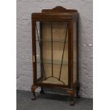 An Art Deco oak display cabinet raised on cabriole supports.