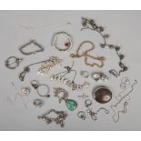 A collection of silver and white metal jewellery to include brooches, charm bracelet, rings,