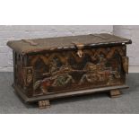 A Spanish carved and polychrome blanket chest with adzed top, large metal clasp and carved in relief