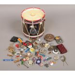 A Queens Regiment drum ice bucket with contents of collectables to include mostly badges.
