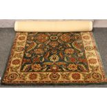 An Indian green ground wool rug with floral design, 180cm x 123cm.