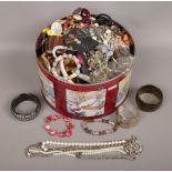 A tin of costume jewellery to include beads, bangles, necklaces, bracelets etc.