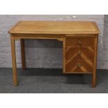 A vintage oak desk with three drawers and slide.