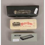 Three cased harmonicas; Hohner marine band, Hohner Chrometta 8 and a Victory.