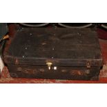 A leather travel trunk with reinforced corners and brass mounts bearing J.B monogrammed initials.