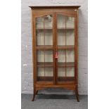 A George V mahogany glazed bookcase with strung inlay and raised on splay supports. (163cm x 85cm